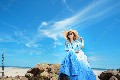 Young woman asian in hawaii dress with hat on the beach summer fun and happy relax in vacation time