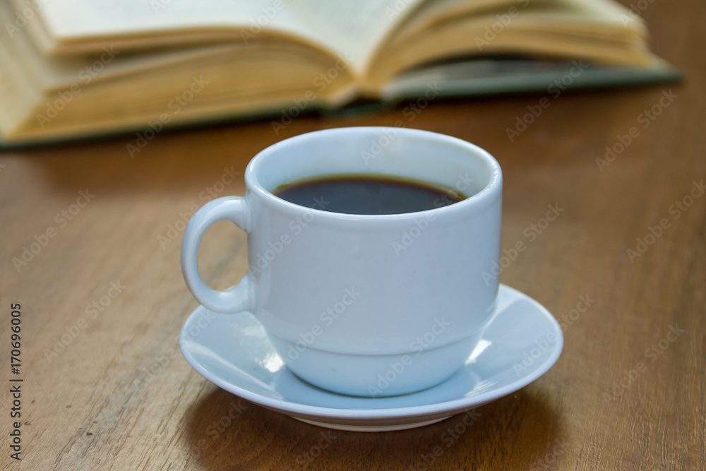 Cup of coffee and book on wooden table Cup of coffee and book on wooden table