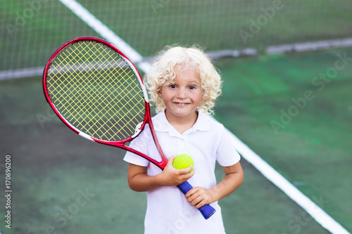 Child playing tennis on outdoor court © famveldman
