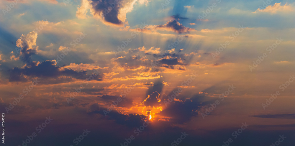 Fototapeta background panorama. rays of the sun make their way through dramatic clouds