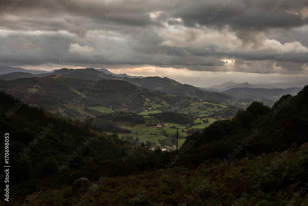 Bosque y pueblo con nubes de tormenta