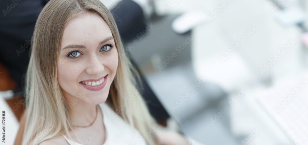 young business woman sitting at a desk in the office . young business woman sitting at a desk in the office .