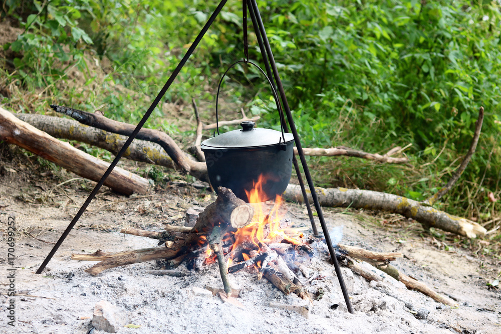 Cooking food in summer on nature at stake in cauldron Cooking food in summer on nature at stake in cauldron