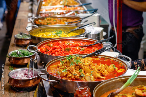Photo Variety of cooked curries on display at Camden Market in London