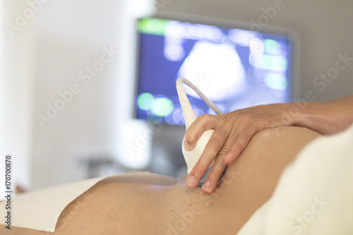 Schwangere Frau bei Ultraschalluntersuchung beim Gynäkologen photo