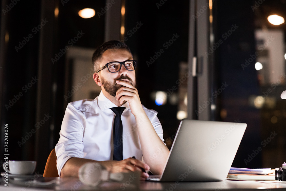 Businessman in the office at night working late. Businessman in the office at night working late.