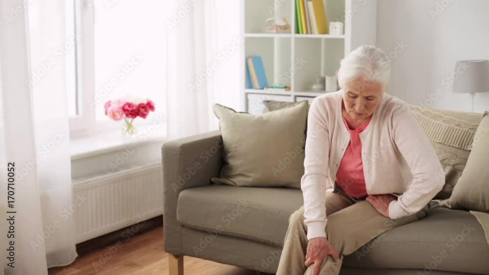 senior woman suffering from pain in leg at home senior woman suffering from pain in leg at home