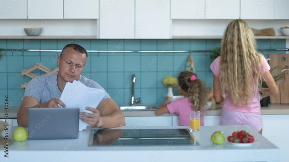 Stressed man browsing bills and documents at home Stressed man browsing bills and documents at home