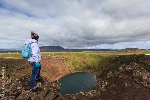 Person enjoys  beautiful northern landscape. Volcanic Kerid crater lake   Iceland   