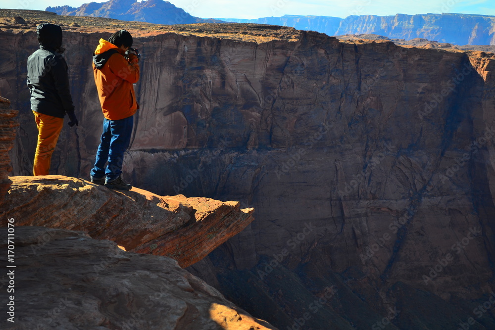 Obraz premium A tourist is taking a photo of Horseshoe Bend near city Page, Arizona