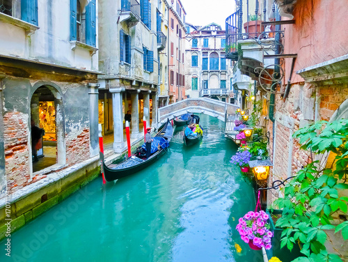 Classical picture of the venetian canals with boats across canal