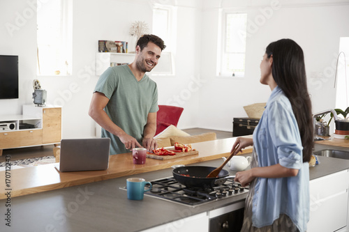 Couple Preparing Meal Together In Modern Kitchen