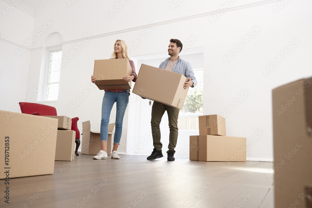 Couple Carrying Boxes Into New Home On Moving Day Couple Carrying Boxes Into New Home On Moving Day