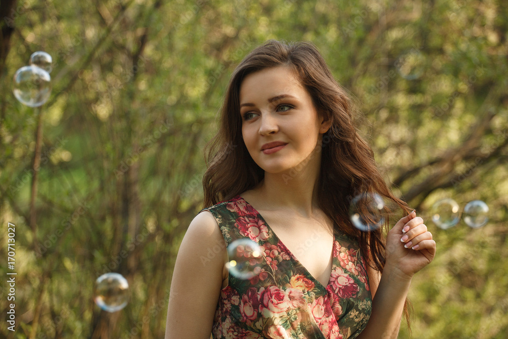 A young beautiful woman and soap bubbles in the park A young beautiful woman and soap bubbles in the park