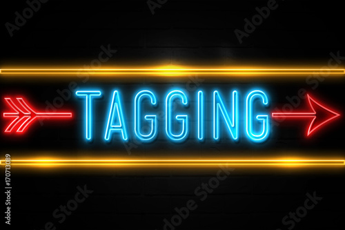 Tagging - fluorescent Neon Sign on brickwall Front view