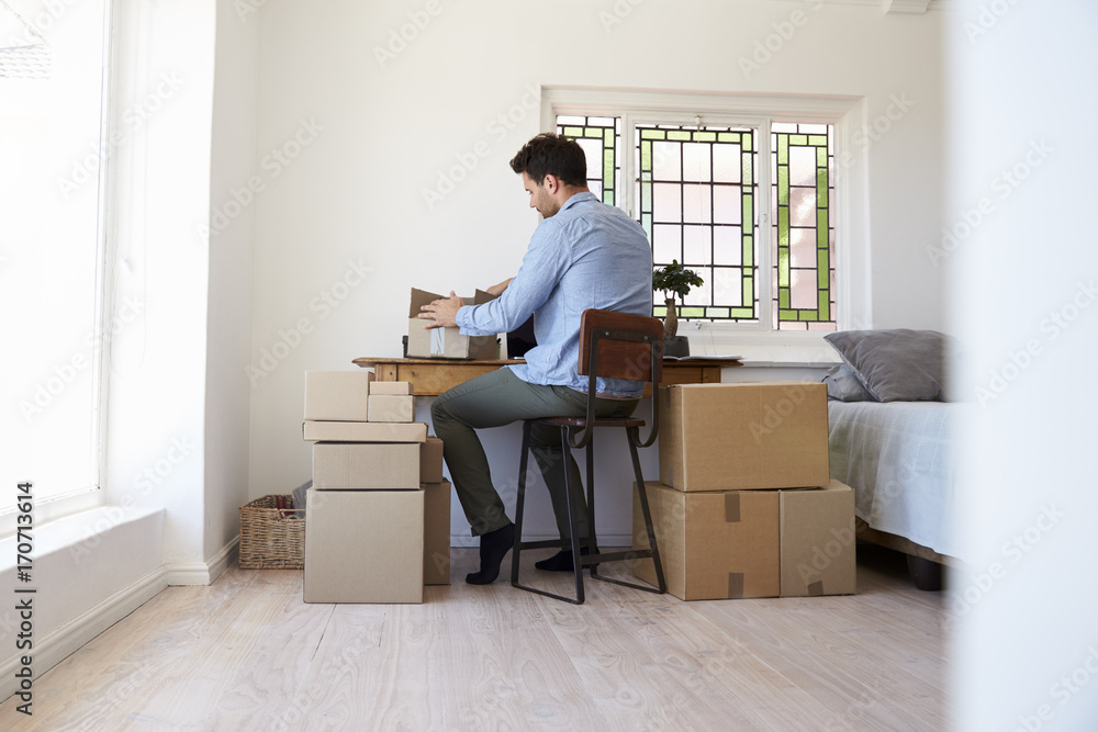 Rear View Of Man Running Business From Home Dispatching Goods Rear View Of Man Running Business From Home Dispatching Goods