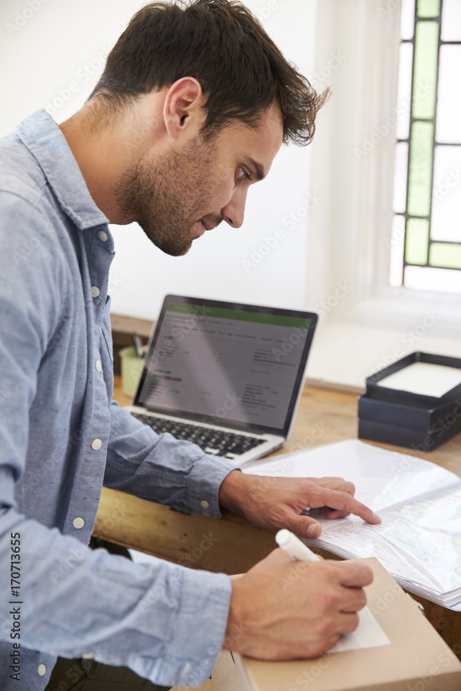 Man In Bedroom Running Business From Home Labeling Goods Man In Bedroom Running Business From Home Labeling Goods