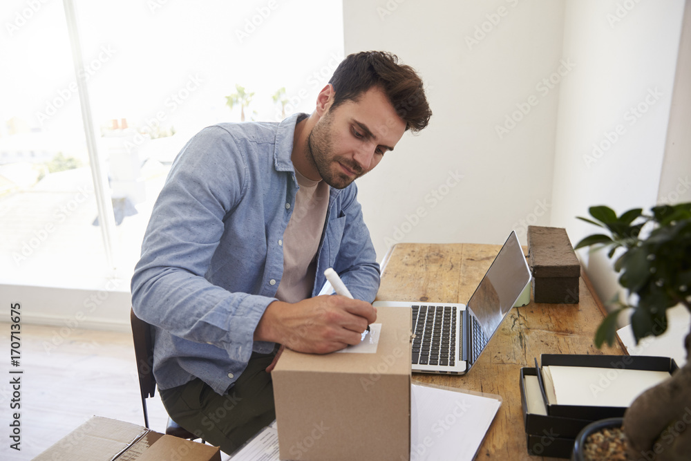 Man In Bedroom Running Business From Home Labeling Goods Man In Bedroom Running Business From Home Labeling Goods