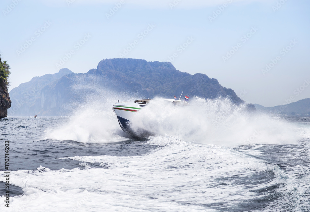 Fototapeta premium speedboat or motorboat sailing on white wave in the tropical sea