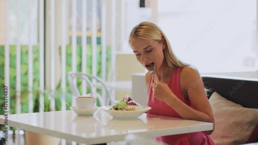 woman eating and drinking coffee at restaurant woman eating and drinking coffee at restaurant