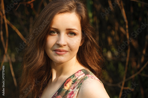 Portait of a young beautiful woman with green eyes and long hair in the sunlight