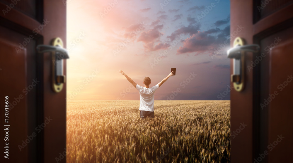 Naklejka premium Man praying to God in the field with doors open