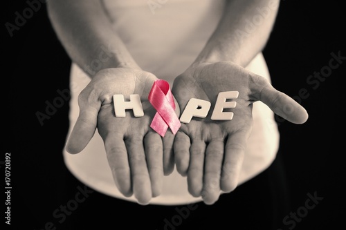 Mid section of woman holding pink ribbon with hope text
