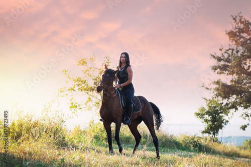 Woman riding a horse in sunset © romul014