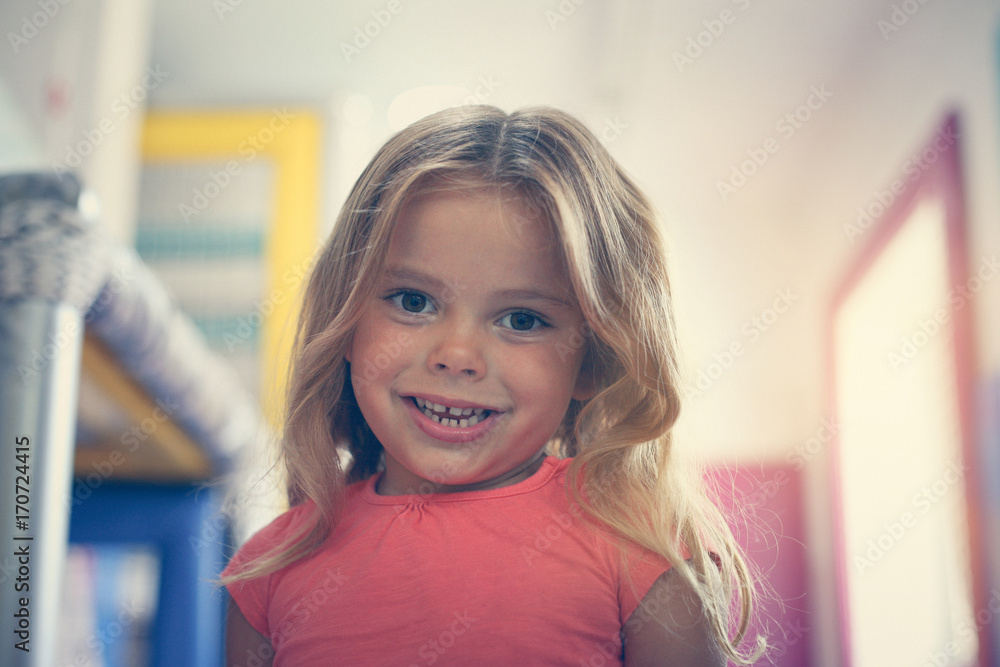 Little girl in playground. Caucasian girl looking at camera.