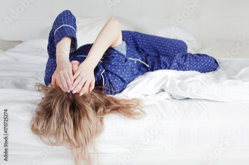 Too lazy to get out of bed, a woman covering her face by hand photo