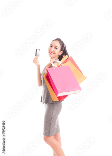 Cheerful shopping woman of Asian holding bags with credit cards. Shopping smart business woman happy smiling holding colorful shopping bags isolated on white . Fresh young Asian female model