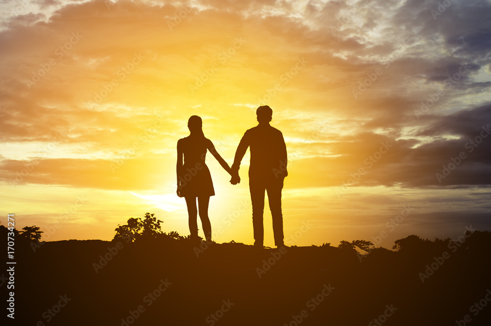 Silhouette Romantic couple in love ,man and women hold hands in nature ,sky with cloud in sunset time