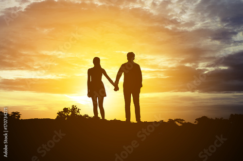 Картината върху платно Silhouette Romantic couple in love ,man and women hold hands in nature ,sky with
