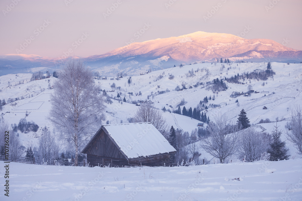 Snowy mountain hills with wooden cabin