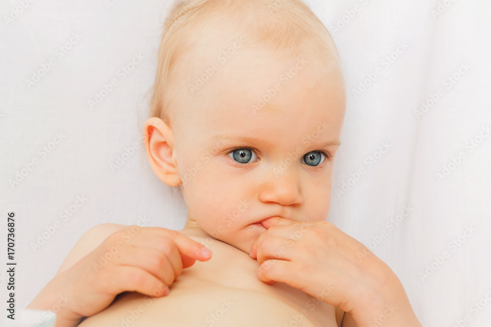 Teething babe portrait. Kid show on a teeth isolated on white background Teething babe portrait. Kid show on a teeth isolated on white background