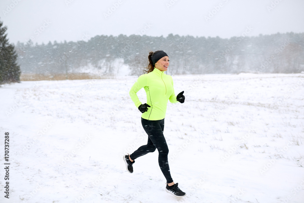 happy woman running along snow covered winter road
