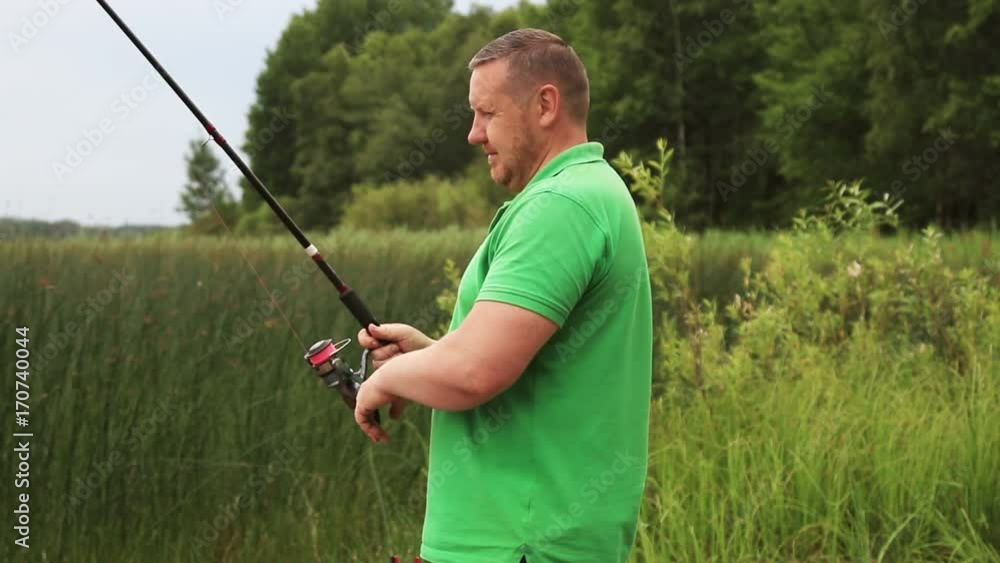 man turns the coil spinning and podmahivat fishing line on the fishing rod man turns the coil spinning and podmahivat fishing line on the fishing rod