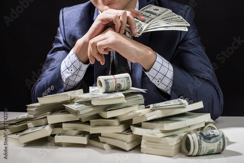 Man holding Money in hand at Black Background, Man receive a lot Money from Trading, Business Success Concept.