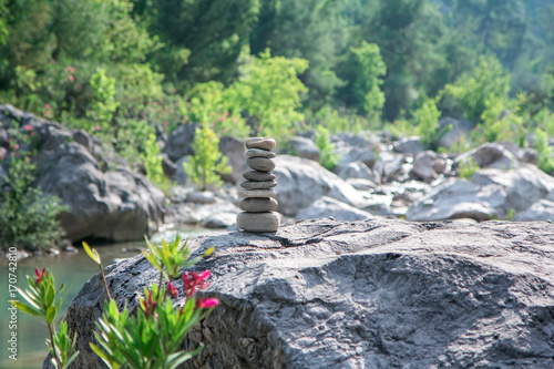 Stones pyramid on rock symbolizing stability, zen, harmony, balance.