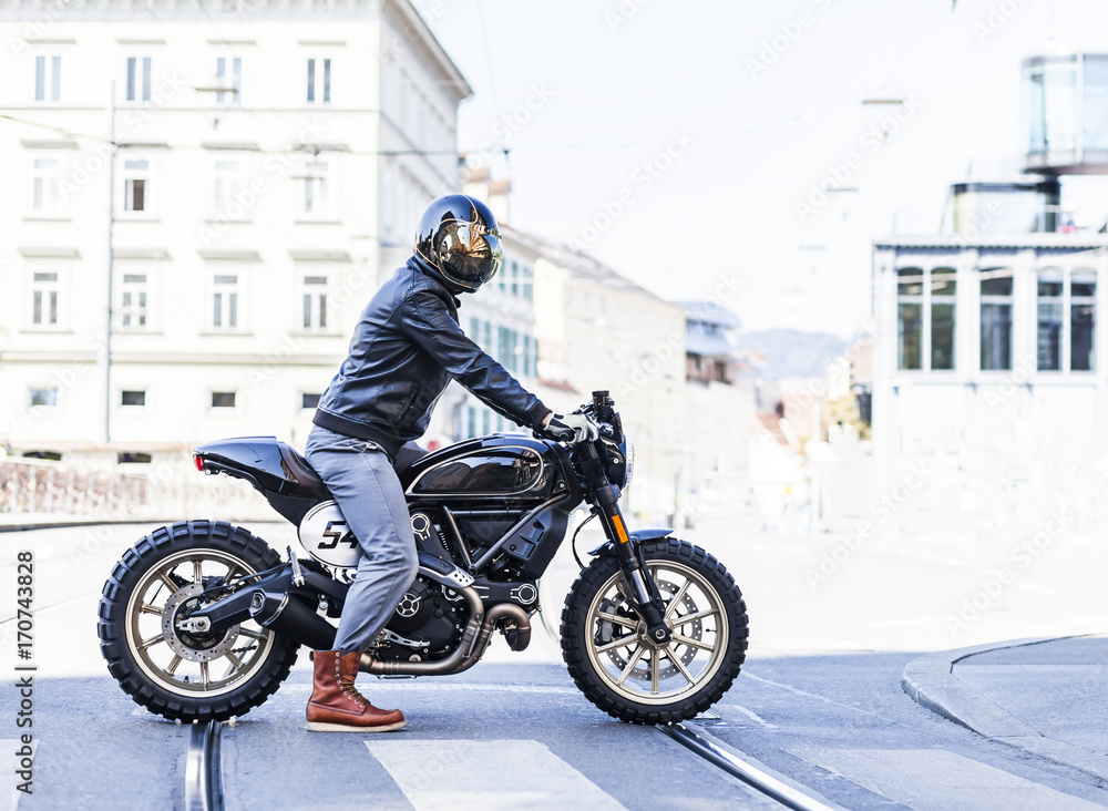 Motorcycle rider on custom made scrambler style cafe racer in the city  Stock Photo | Adobe Stock