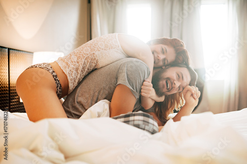 Happy couple in bed showing emotions