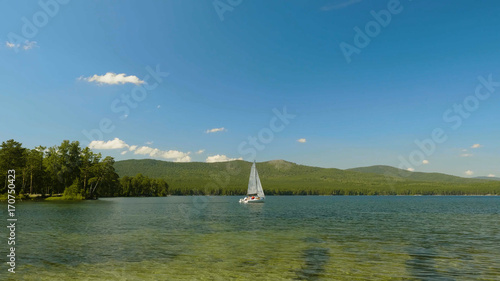 Sailboat on the water. Sailboats on the beautiful Lake of the. White sailboat floating on the lake photo