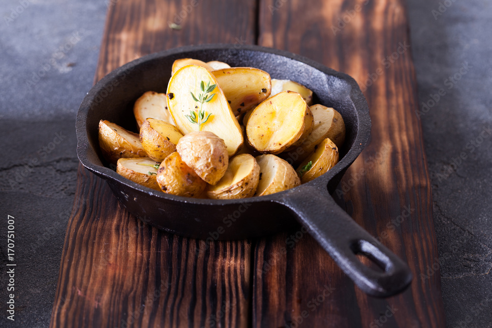 Baked spicy potatoes with thyme on parchment Baked spicy potatoes with thyme on parchment