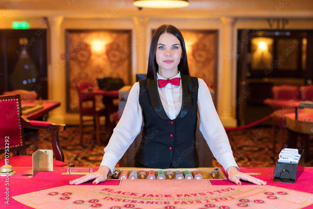Fototapeta premium Cute lady casino dealer at poker table.