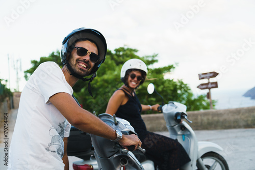 Smiling people posing on scooters photo