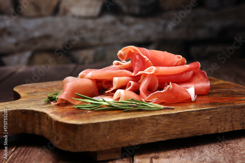 Italian prosciutto crudo or jamon with rosemary. Raw ham. photo