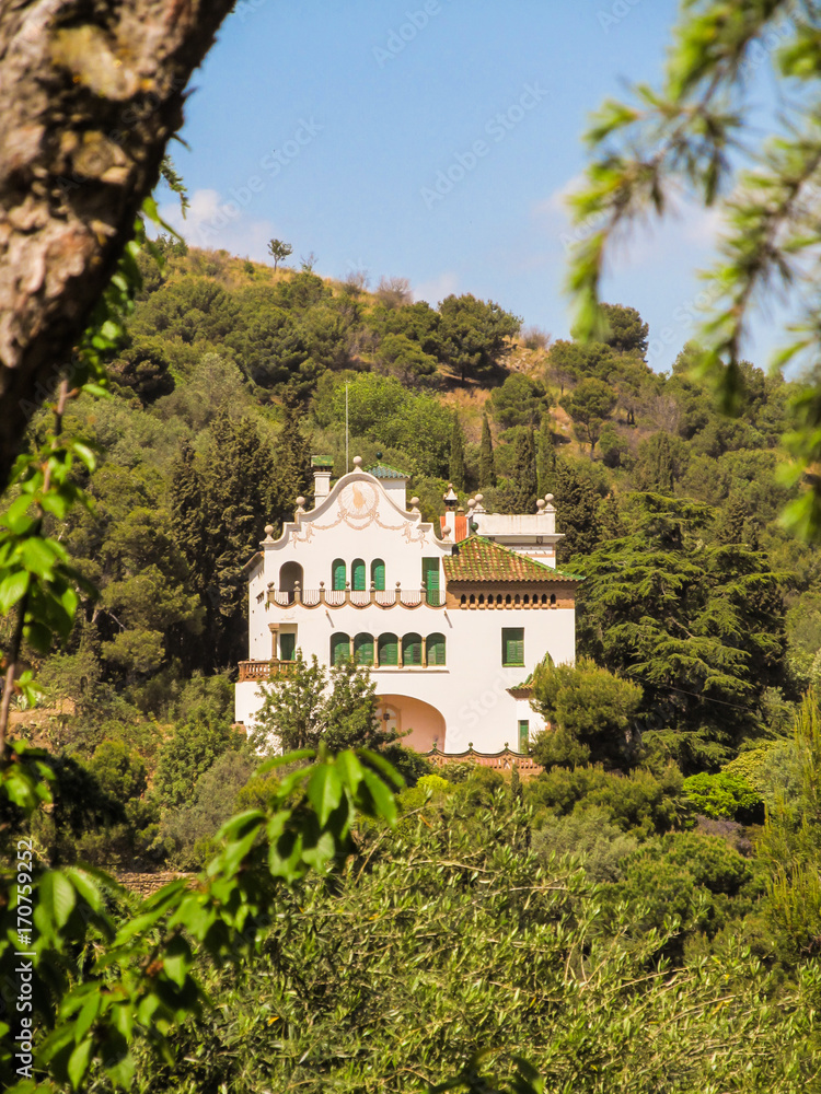 La Casa Trias among trees at Park Guell in Barcelona, Spain