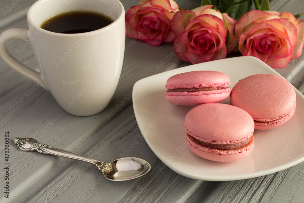 Pink macaroons and coffee on the grey wooden background Pink macaroons and coffee on the grey wooden background