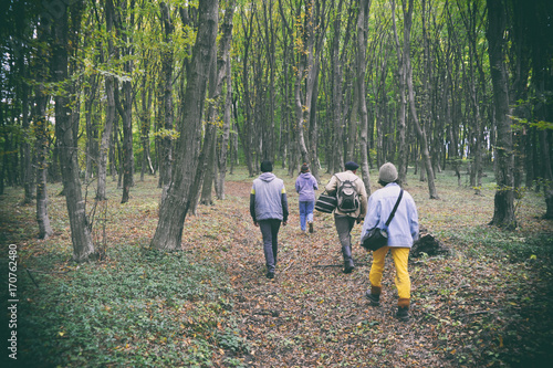 Film photos of group of people on the walk. Family in the hike. People go up the road.