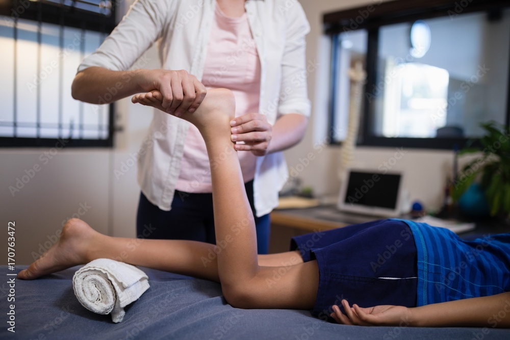 Fototapeta premium Low section of boy receiving foot massage from young female